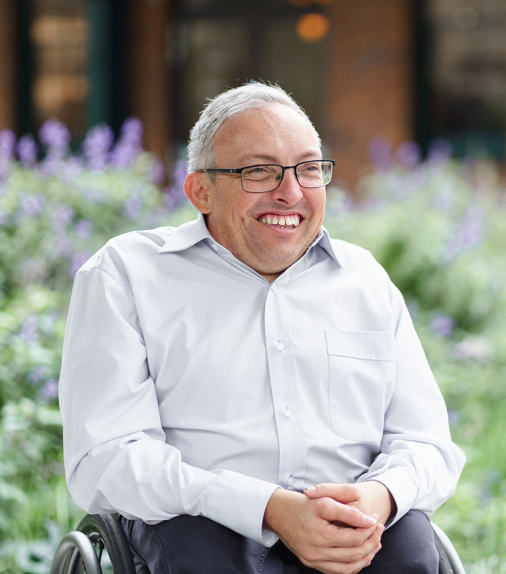 Image description: David Belcher smiling in front of lavendar bushes