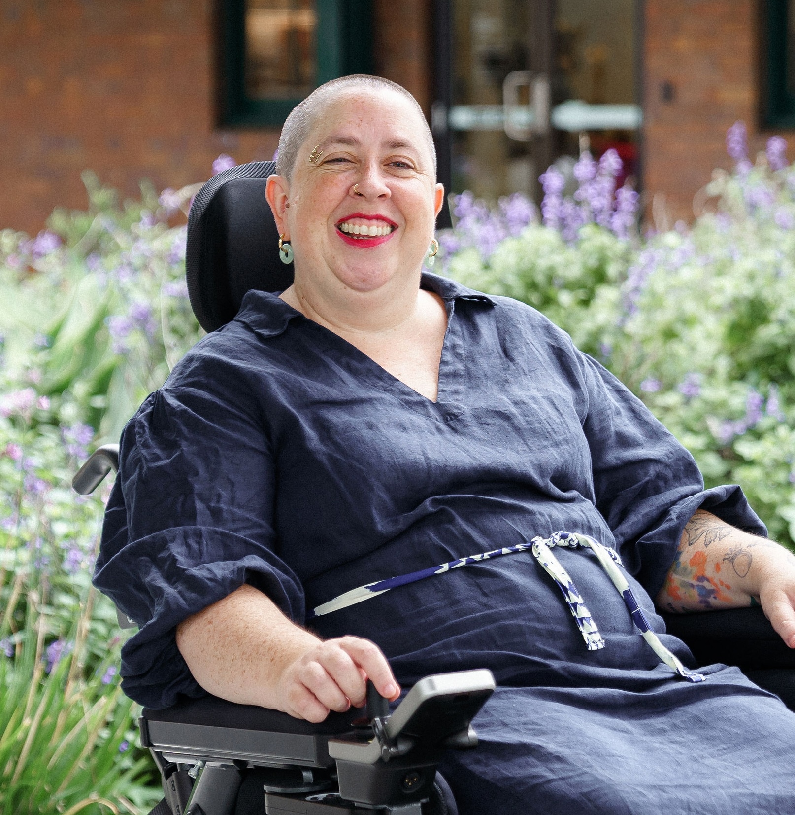 Image description: Catherine Caine smiling in front of lavendar bushes